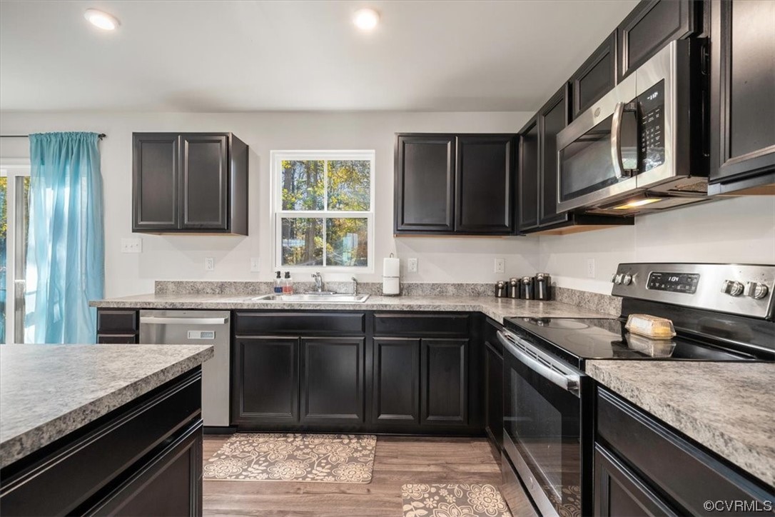 8443 Evening Star Place Richmond, VA 23235 - Photo 25 of 33 a kitchen with stainless steel appliances granite countertop a sink stove and refrigerator