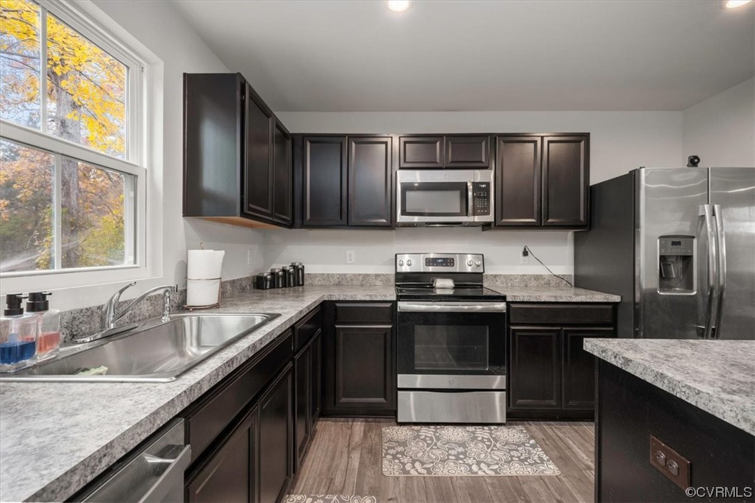 8443 Evening Star Place Richmond, VA 23235 - Photo 3 of 33 a kitchen with kitchen island granite countertop a sink stove and refrigerator