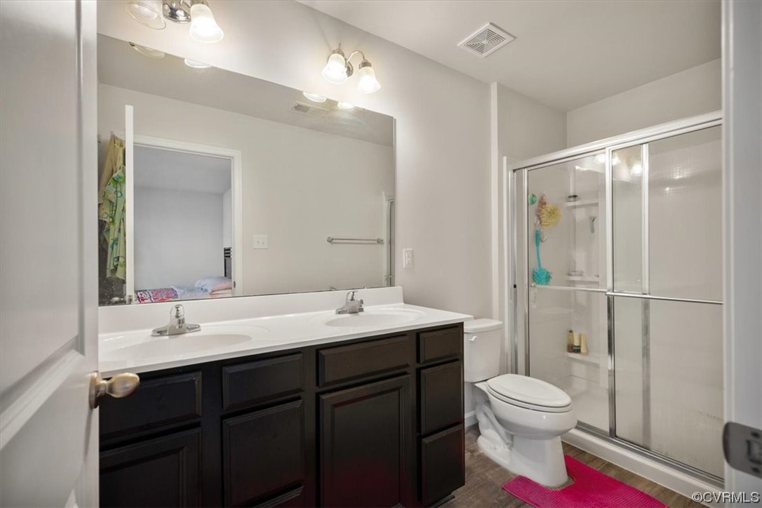 8443 Evening Star Place Richmond, VA 23235 - Photo 5 of 33 a bathroom with a toilet sink a mirror and shower