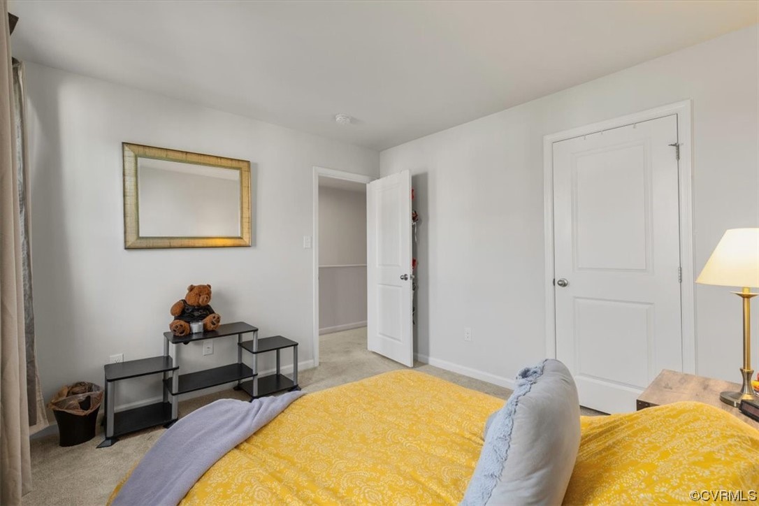 8443 Evening Star Place Richmond, VA 23235 - Photo 9 of 33 a bedroom with a bed and a lamp on dresser