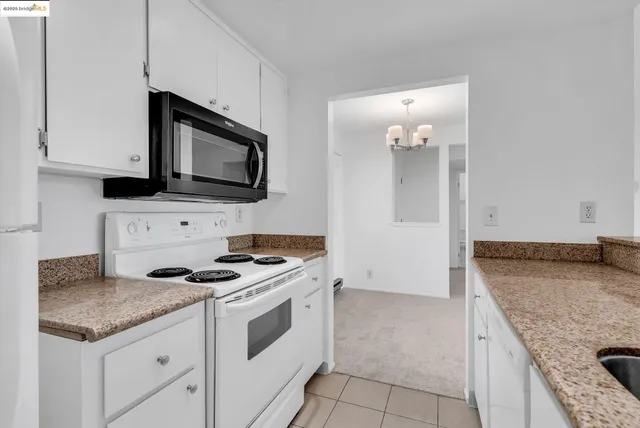 a kitchen with granite countertop a stove sink and microwave