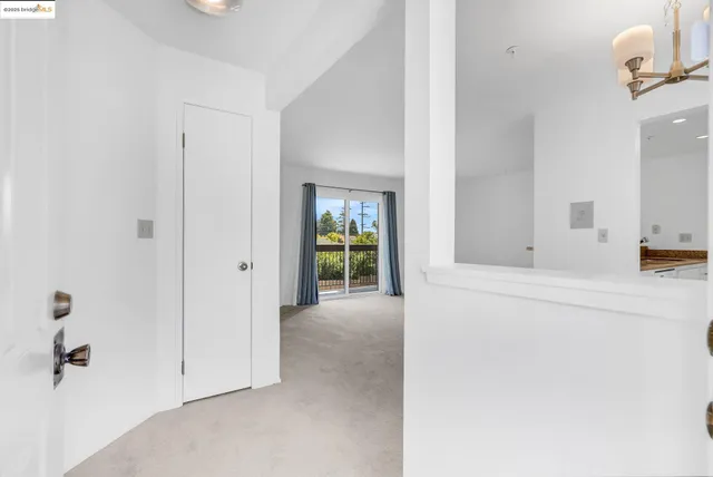 a view of a hallway with wooden floor and a bathroom