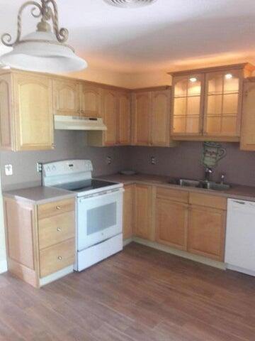 721 Southeast Stypmann Boulevard Stuart, FL 34994 - Photo 2 of 9 a kitchen with a white cabinets and wooden floor