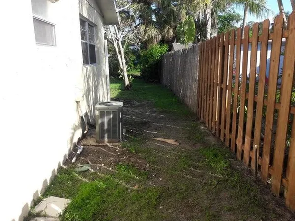 a view of a backyard with wooden fence