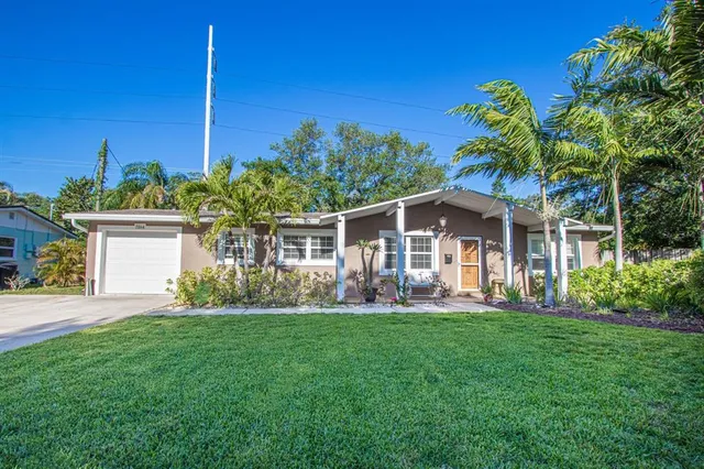 a front view of a house with a yard and potted plants
