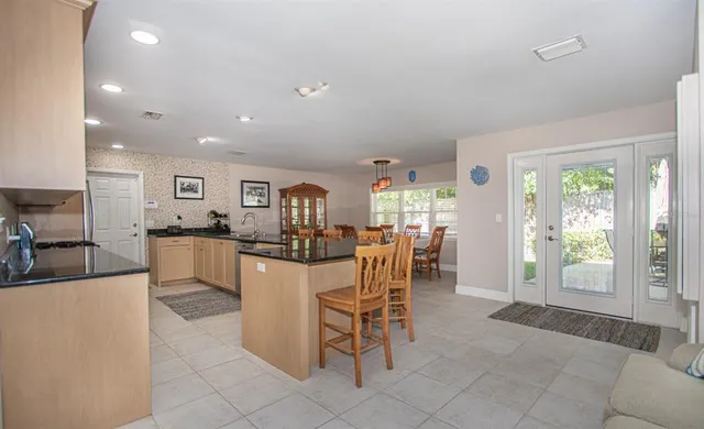 a kitchen with a dining table chairs and large window