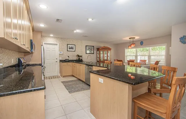 a kitchen with granite countertop a sink stainless steel appliances and cabinets