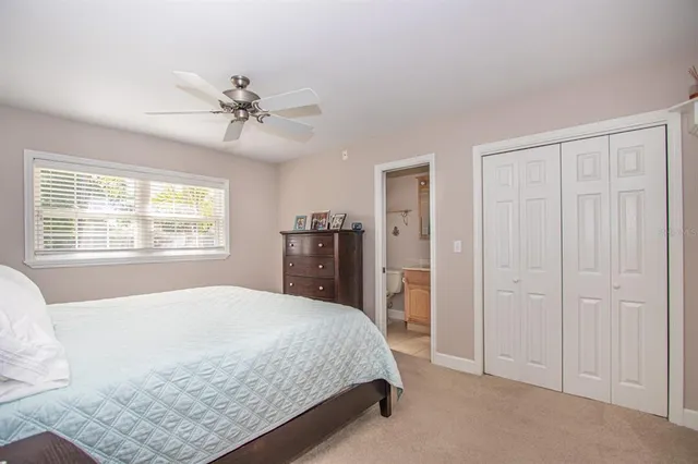 a spacious bedroom with a bed and a chandelier