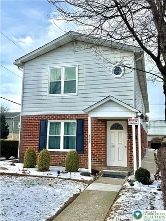 a view of a house with a yard and large tree