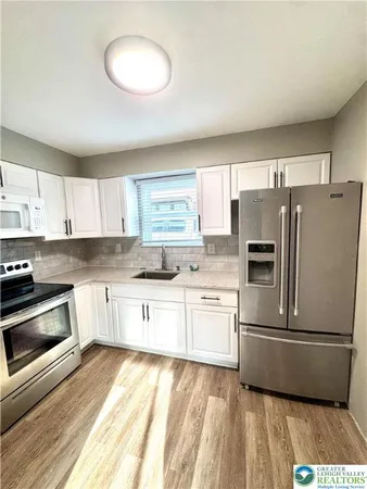 a kitchen with granite countertop a refrigerator stove top oven and sink