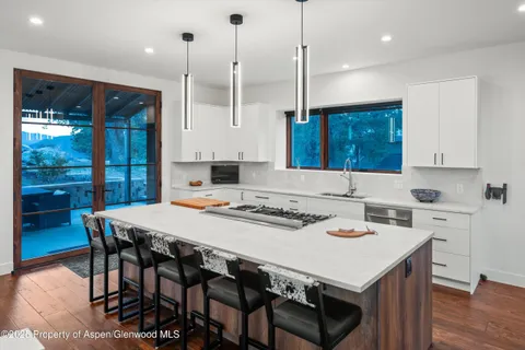 a kitchen with a stove a table a sink and cabinets