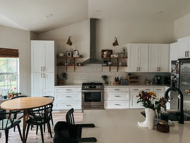 a kitchen with a table chairs a stove a sink a dining table and chairs