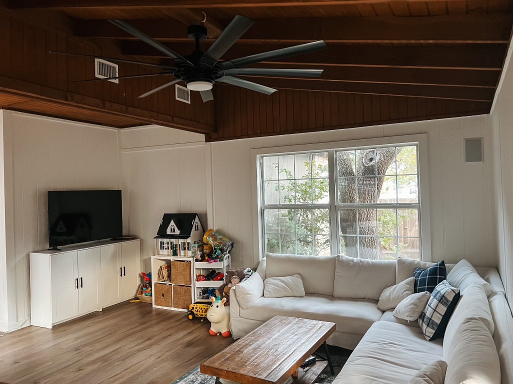 1000 Blue Bird Court Round Rock, TX 78681 - Photo 2 of 10 a living room with furniture a flat screen tv and a floor to ceiling window