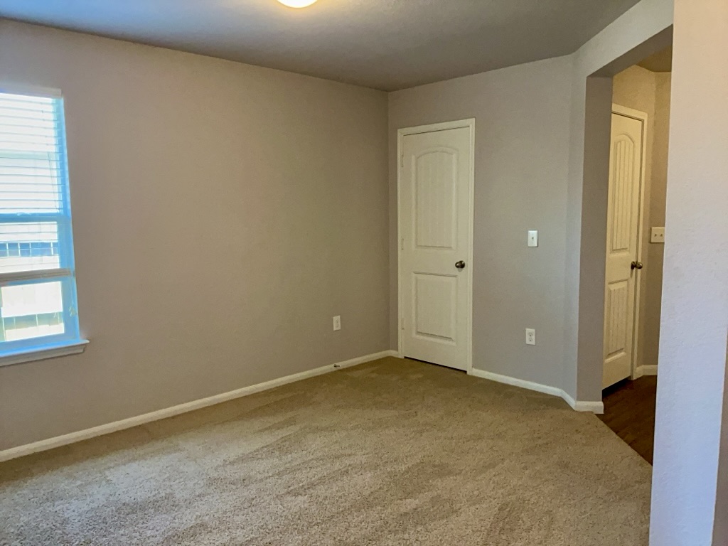 12040 Riparian Road Manor, TX 78653 - Photo 8 of 23 Soft carpeting underfoot and neutral wall finishes define this quiet bedroom space.