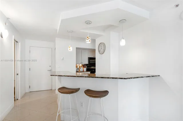 a kitchen with granite countertop a sink and a refrigerator