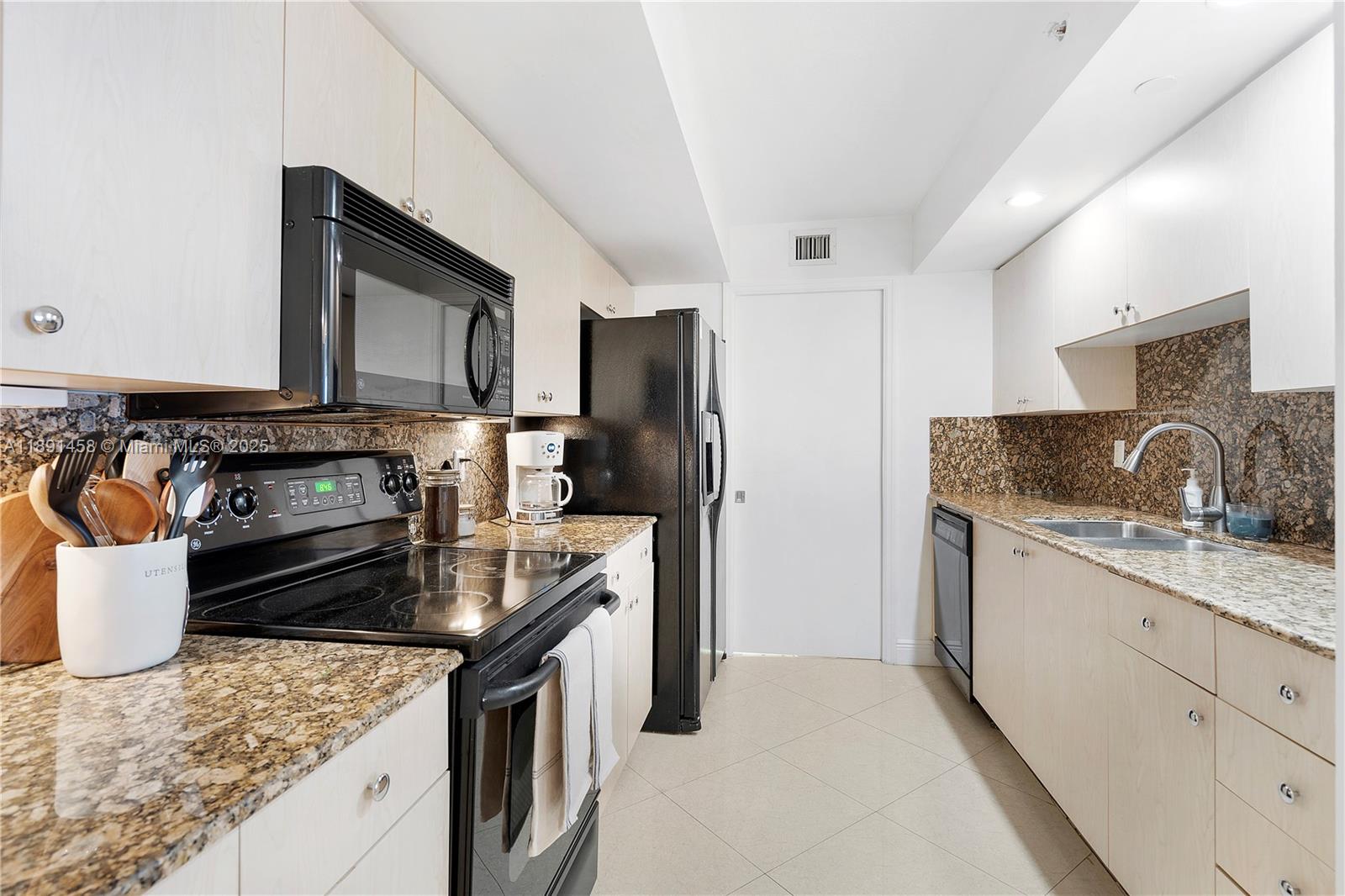 6917 Collins Avenue, Unit 508 Miami Beach, FL 33141 - Photo 6 of 18 a kitchen with stainless steel appliances granite countertop a sink stove and refrigerator
