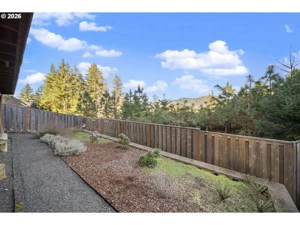 a view of a backyard with wooden fence