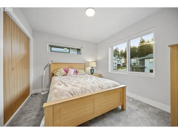 a bed sitting in a bedroom next to a window