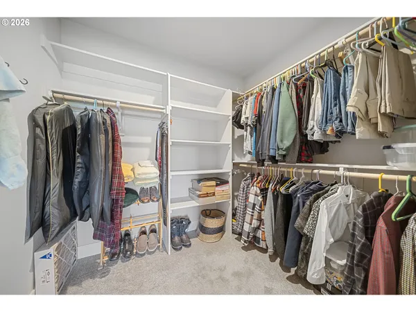 a view of walk in closet with clothes and shoes