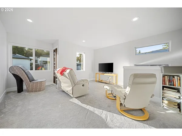 a living room with furniture a window and a flat screen tv