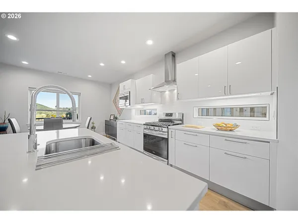 a kitchen with a sink white cabinets and white appliances