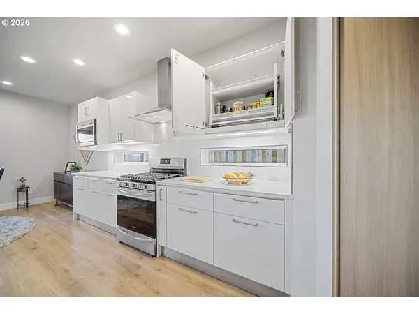 a kitchen with a stove and white cabinets