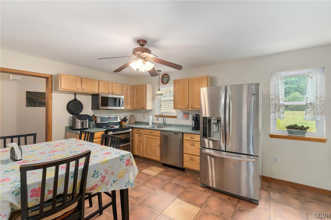 205 Ryan Road Blakeslee, PA 18610 - Photo 5 of 34 a kitchen with stainless steel appliances granite countertop a refrigerator a stove a sink a dining table and chairs with wooden floor