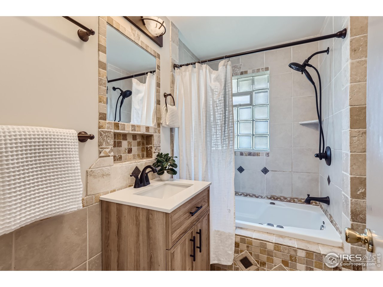 25 Reed Place Longmont, CO 80504 - Photo 12 of 30 a bathroom with a sink mirror and a bathtub