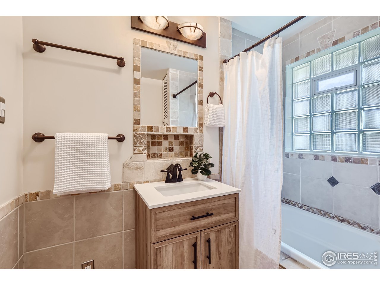 25 Reed Place Longmont, CO 80504 - Photo 14 of 30 a bathroom with a sink a mirror and a shower