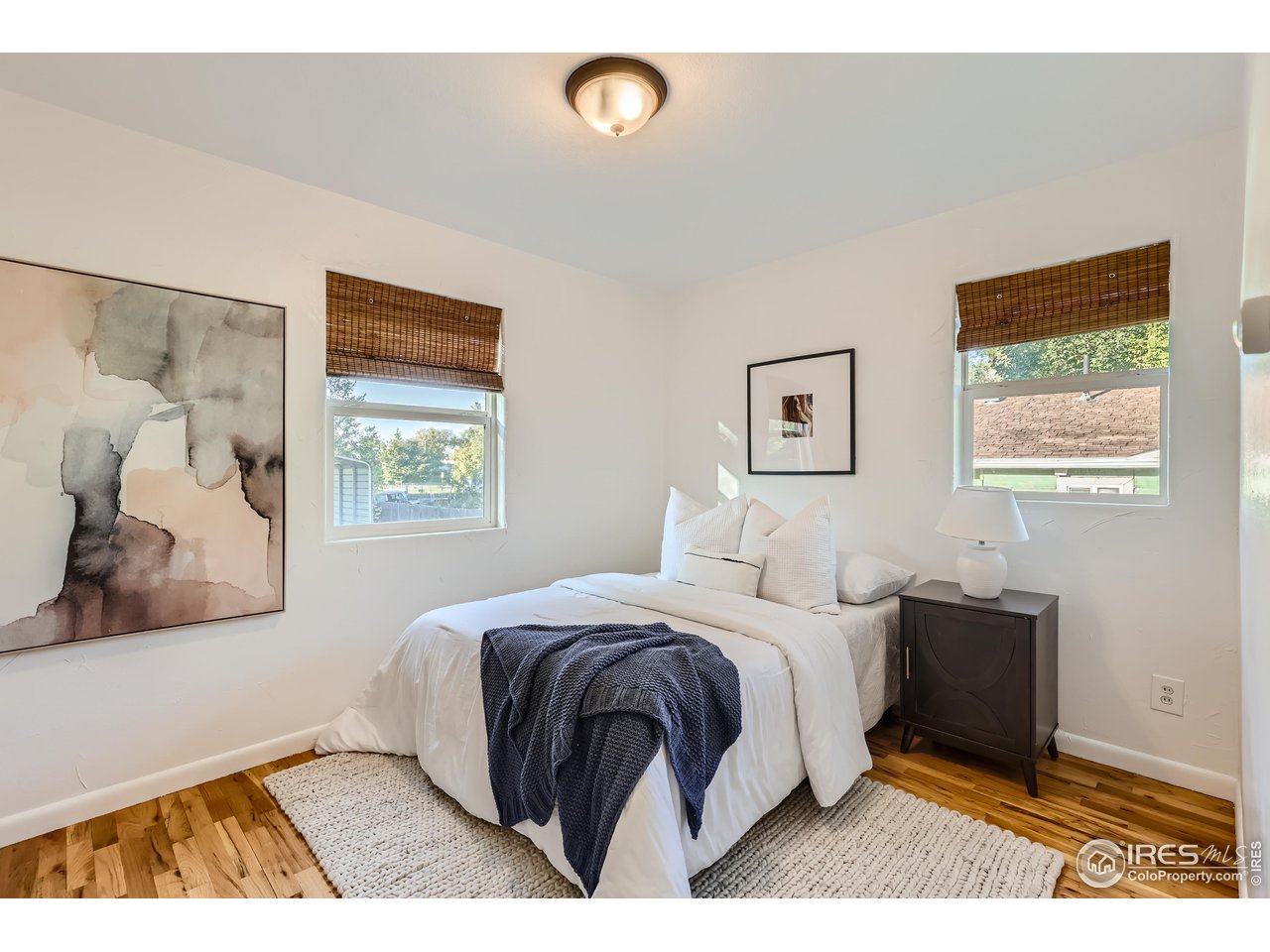 25 Reed Place Longmont, CO 80504 - Photo 15 of 30 a bedroom with a bed and a painting on the wall