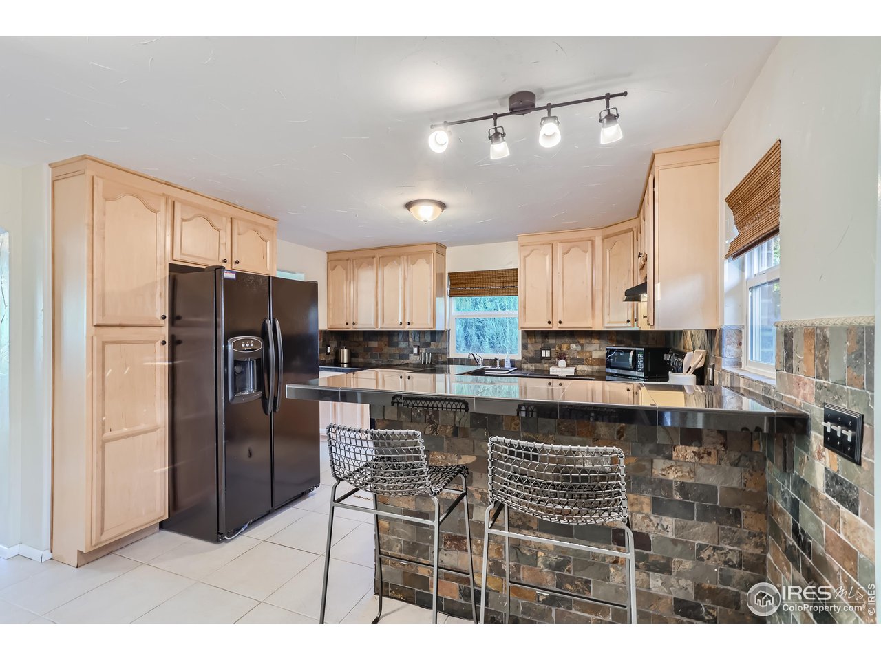 25 Reed Place Longmont, CO 80504 - Photo 7 of 30 a kitchen with stainless steel appliances a refrigerator sink and cabinets