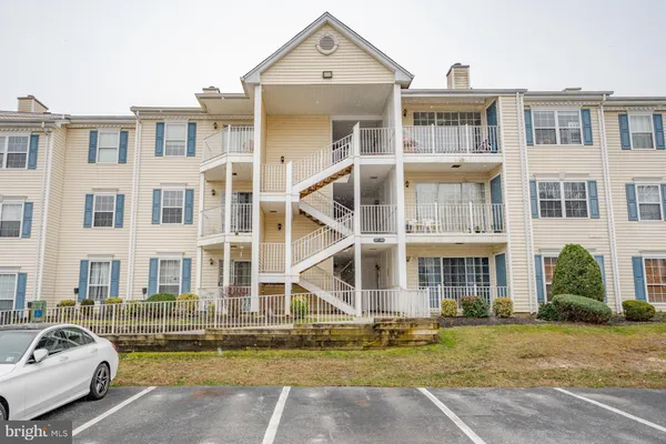a front view of a residential apartment building with a swimming pool