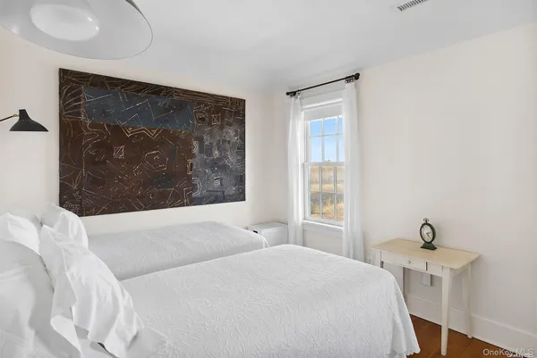 a bedroom with a bed and a painting on the wall