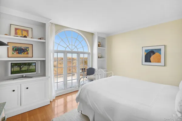 a bedroom with a bed and a large window