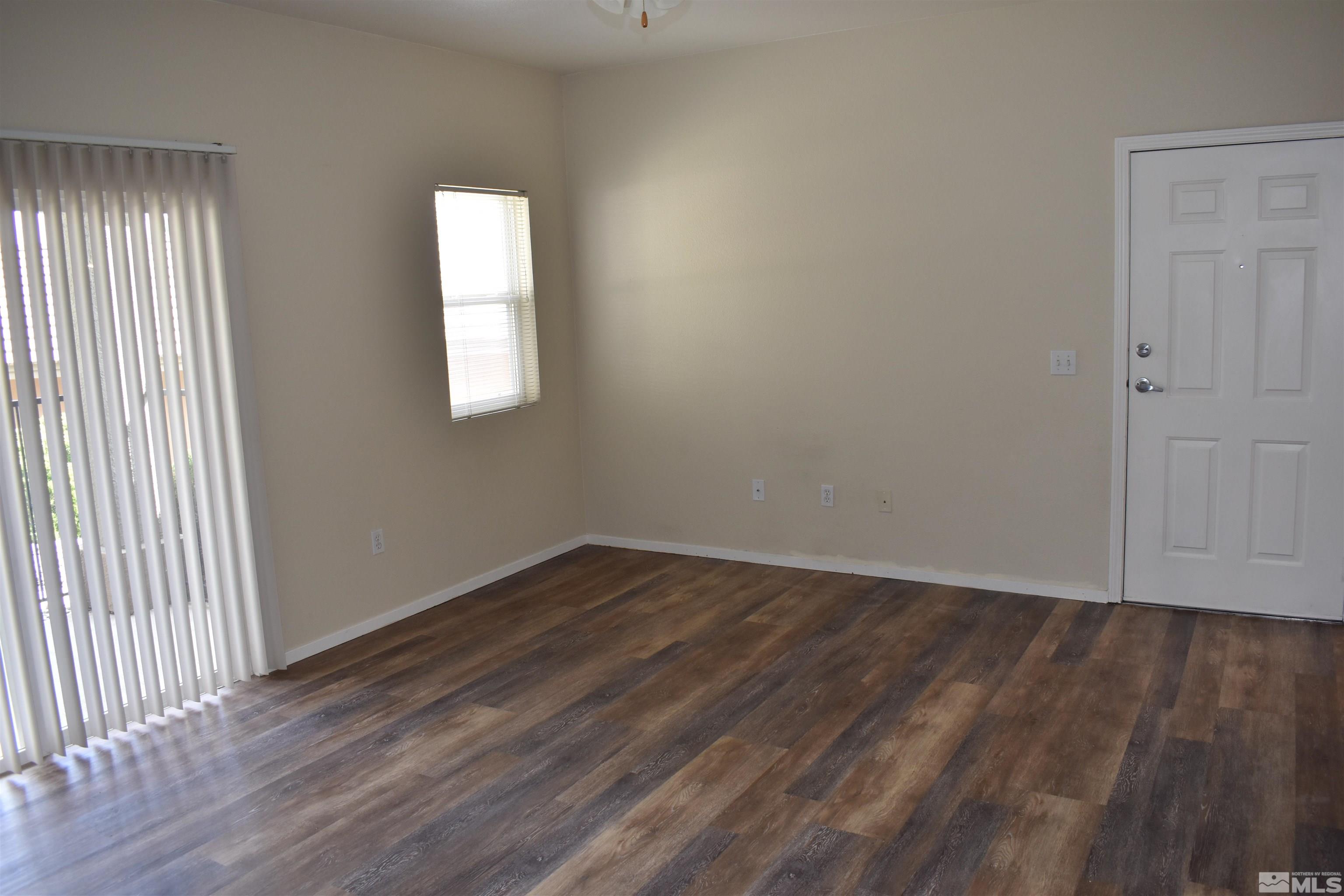 6850 Sharlands Avenue, Unit W1133 Reno, NV 89523 - Photo 3 of 17 an empty room with wooden floor and windows