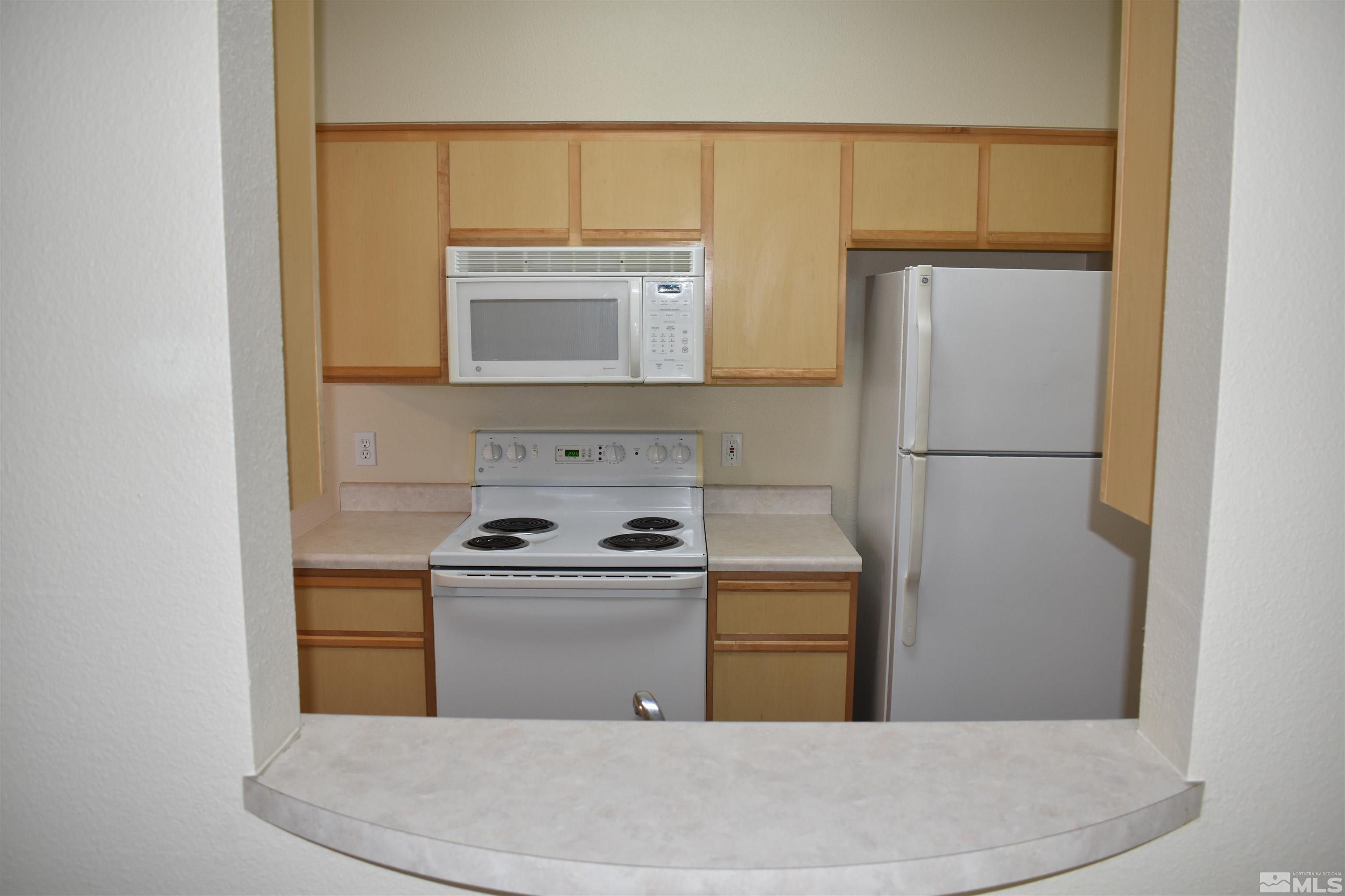 6850 Sharlands Avenue, Unit W1133 Reno, NV 89523 - Photo 5 of 17 a kitchen with a refrigerator sink and microwave