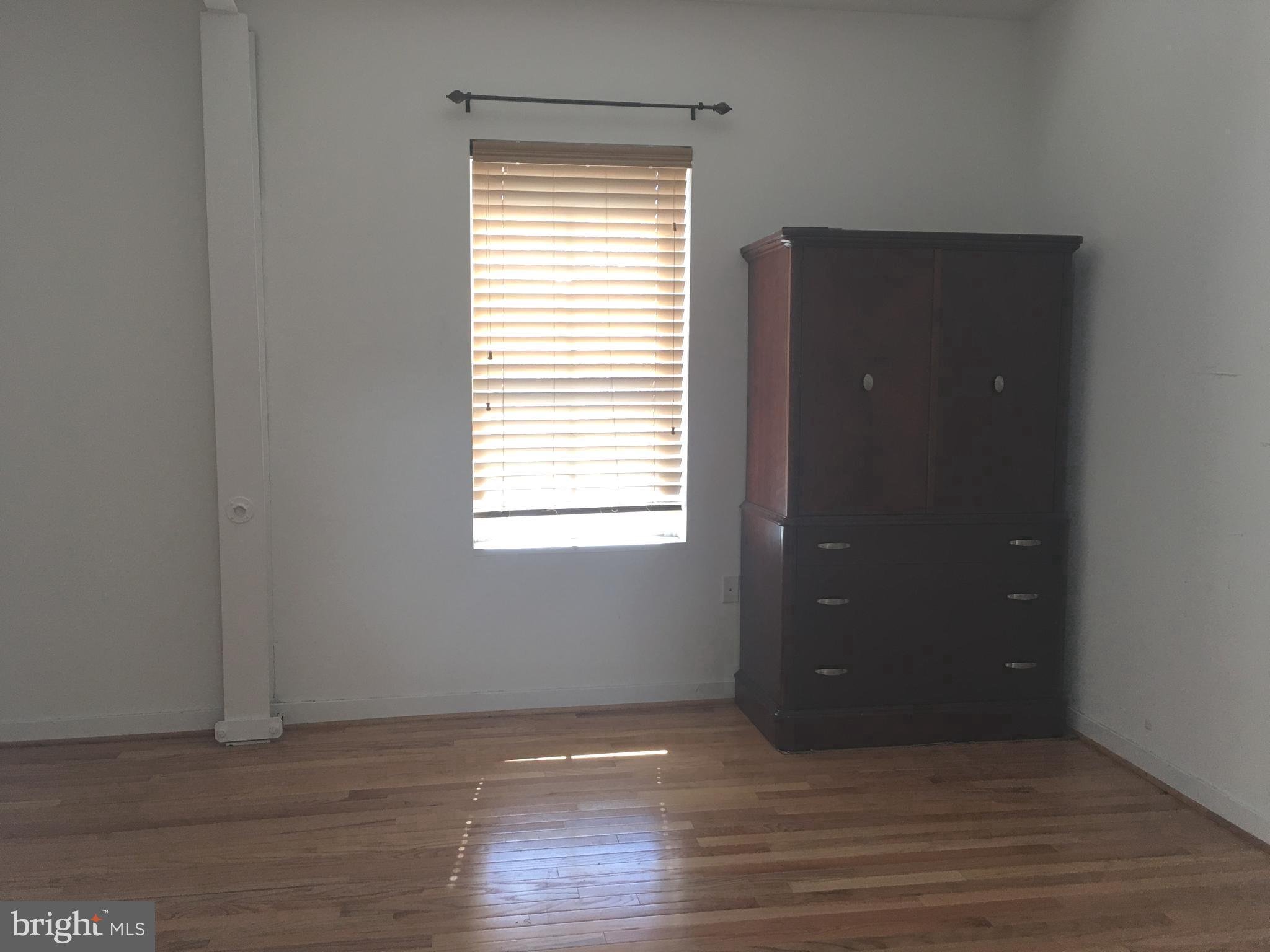 242 Centre Street, Unit 12 Trenton, NJ 08611 - Photo 16 of 23 a view of an empty room with wooden floor and a window