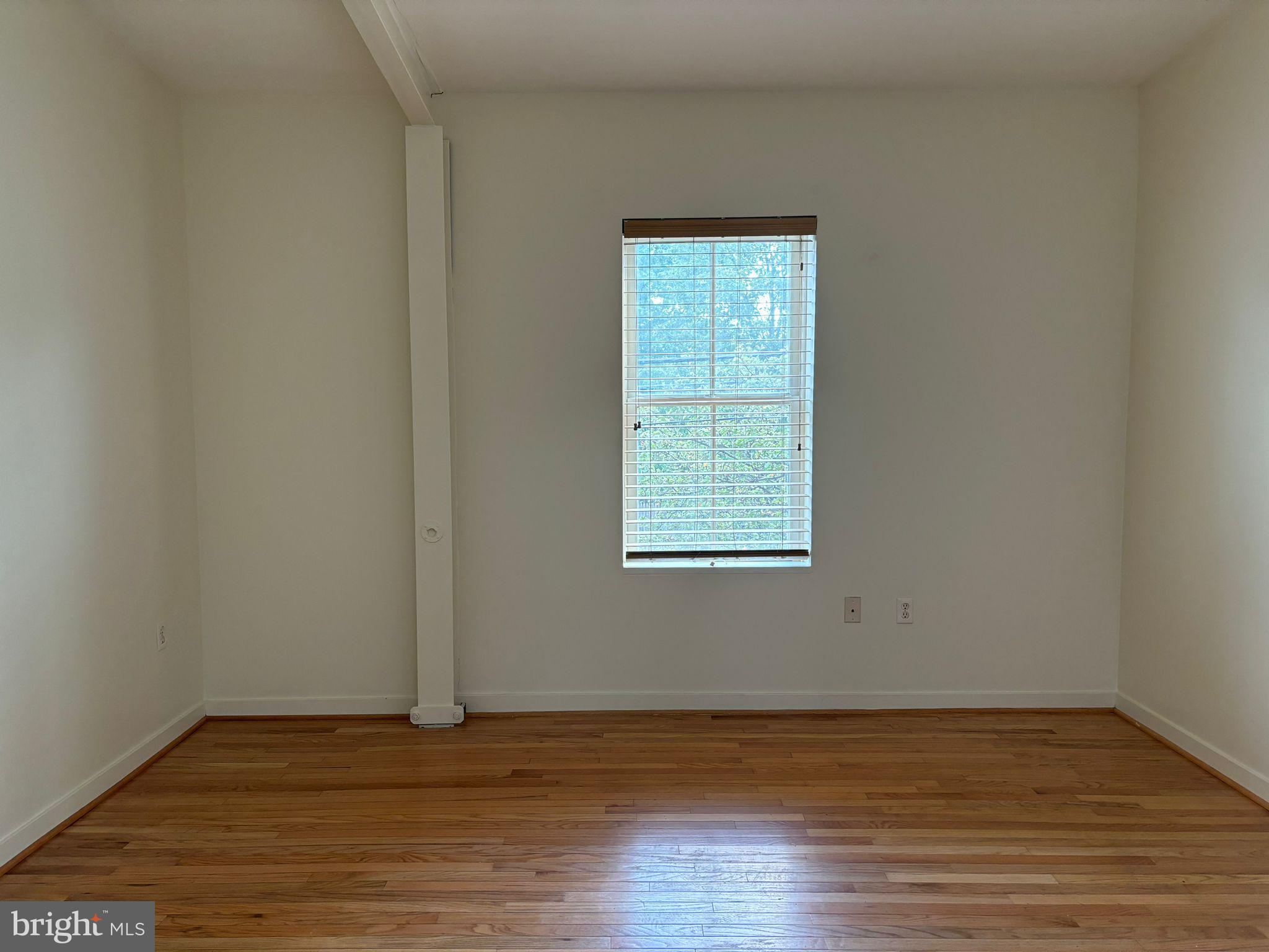 242 Centre Street, Unit 12 Trenton, NJ 08611 - Photo 17 of 23 a view of an empty room with wooden floor and a window