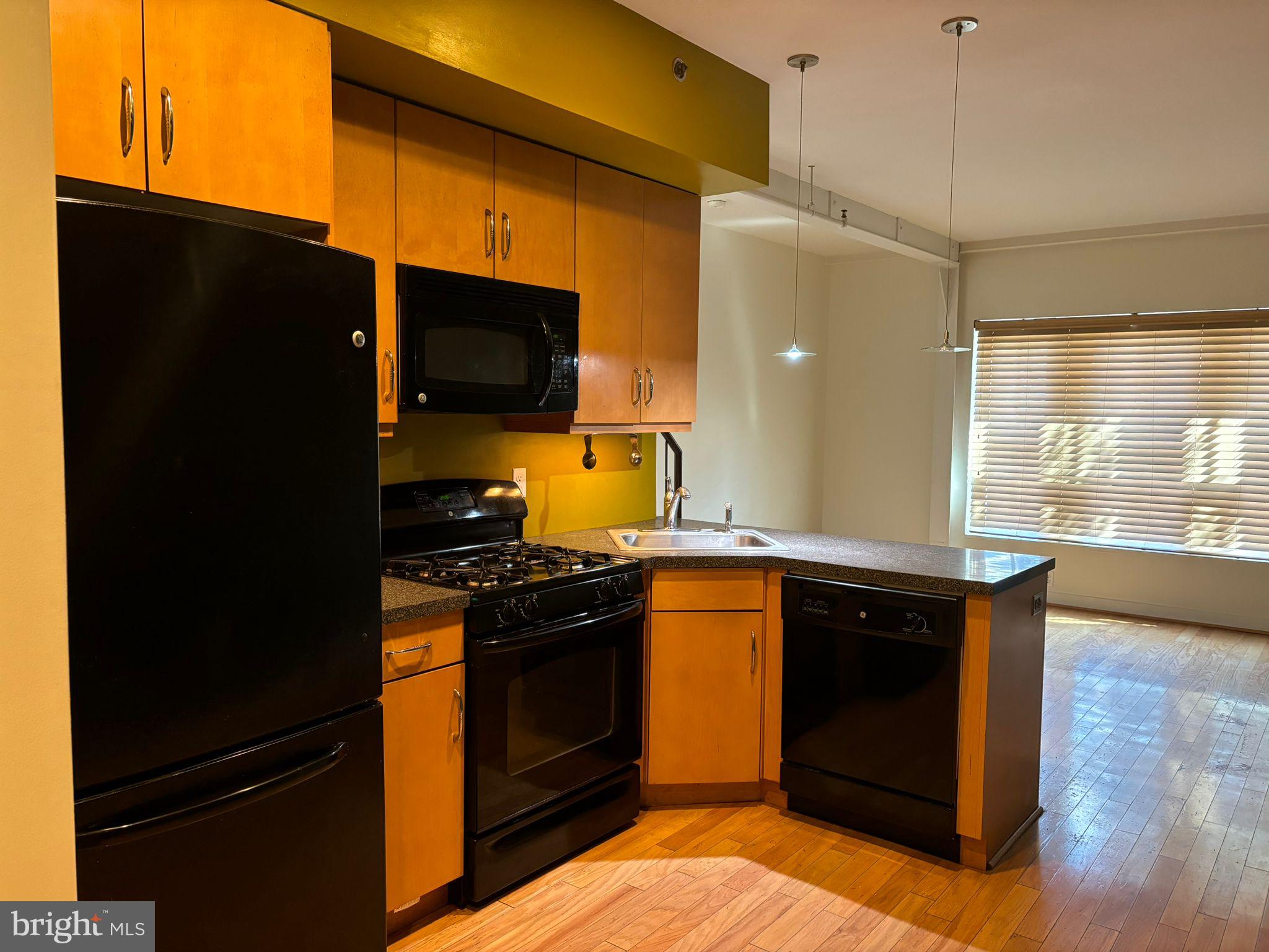 242 Centre Street, Unit 12 Trenton, NJ 08611 - Photo 10 of 23 a kitchen with stainless steel appliances granite countertop a stove a refrigerator and a microwave