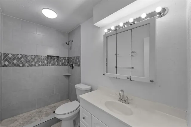 a bathroom with a sink a toilet and mirror