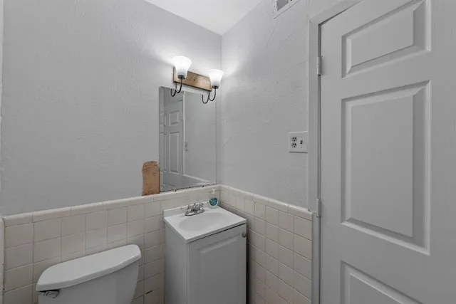a bathroom with a sink a toilet and a mirror