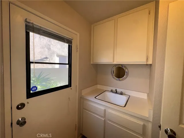 a bathroom with a window sink and mirror
