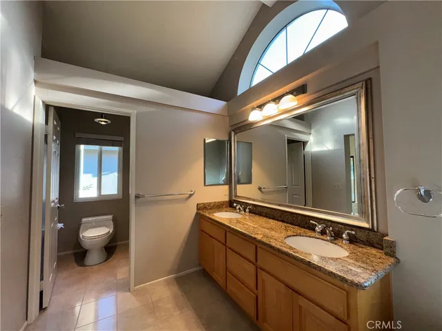 a spacious bathroom with a granite countertop sink and a mirror