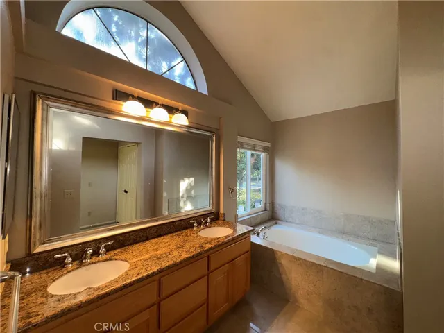 a spacious bathroom with a granite countertop tub sink and mirror