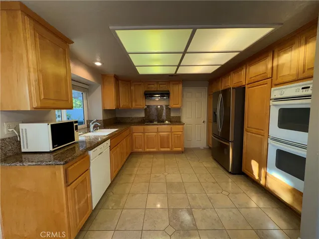 a large kitchen with stainless steel appliances granite countertop a stove a sink and dishwasher