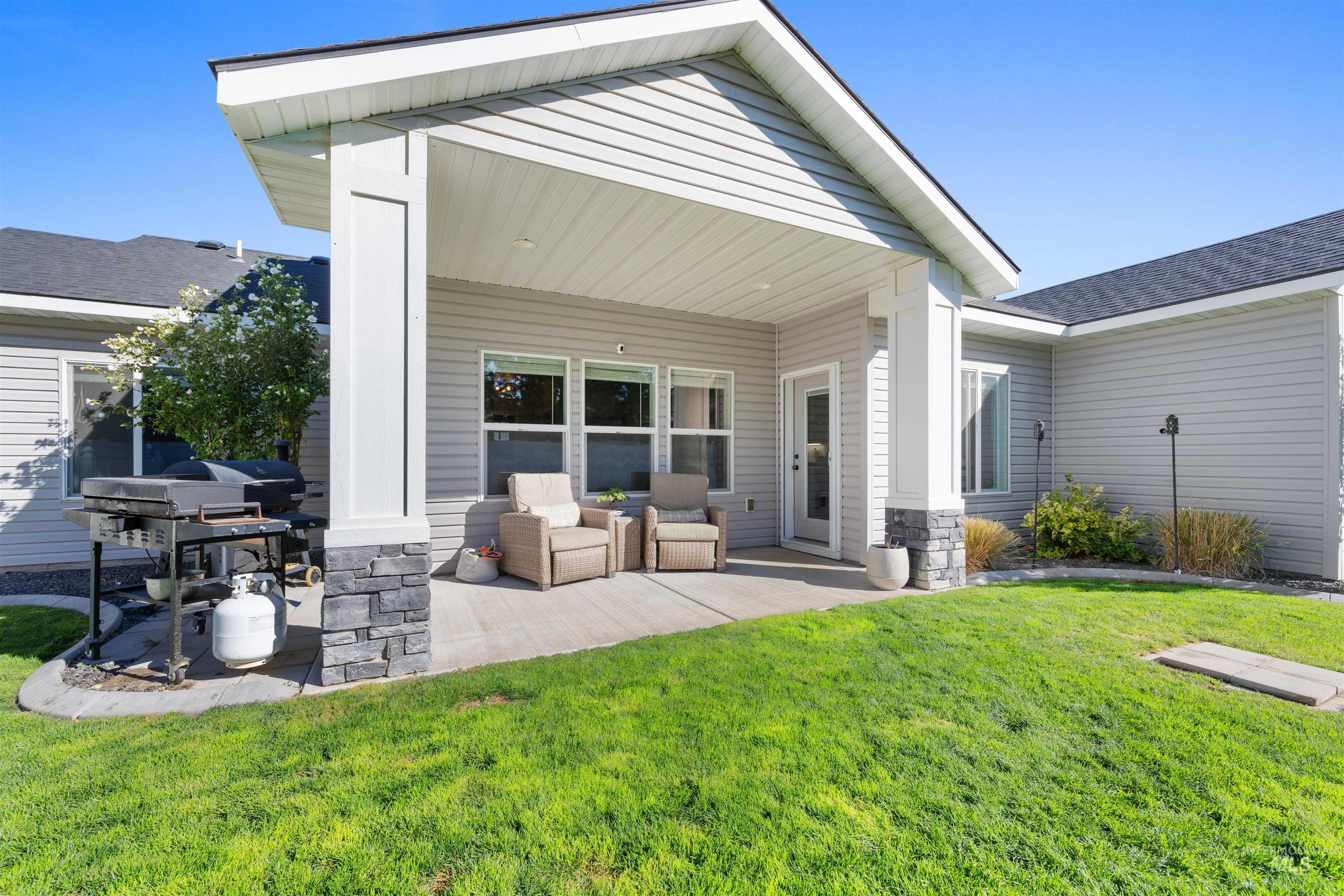 2958 Sunlight Road Twin Falls, ID 83301 - Photo 37 of 40 Covered patio featuring stone-clad pillars, siding exterior, and a glass-paneled exterior door