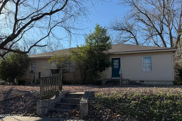 a backyard of house with large trees