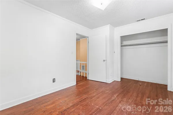 an empty room with wooden floor & closet