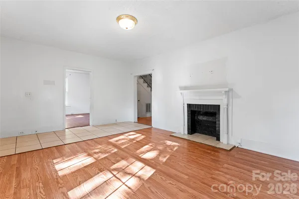 a view of empty room with wooden floor and fireplace
