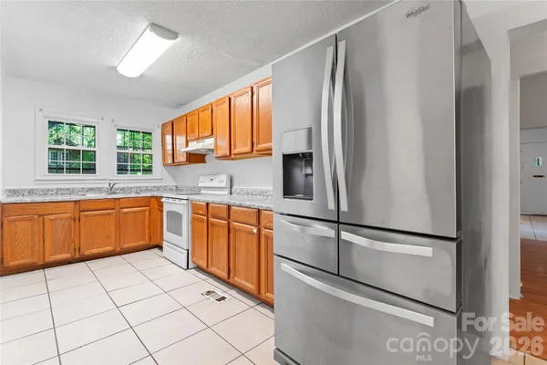 a kitchen with stainless steel appliances granite countertop a refrigerator sink and window